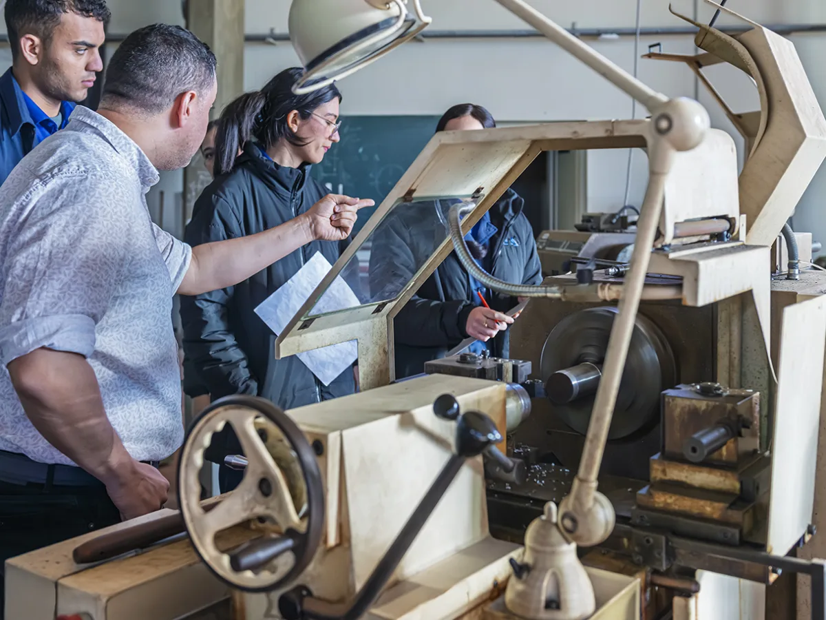 Atelier d'usinage : élèves ingénieurs encadrés sur machine-outil